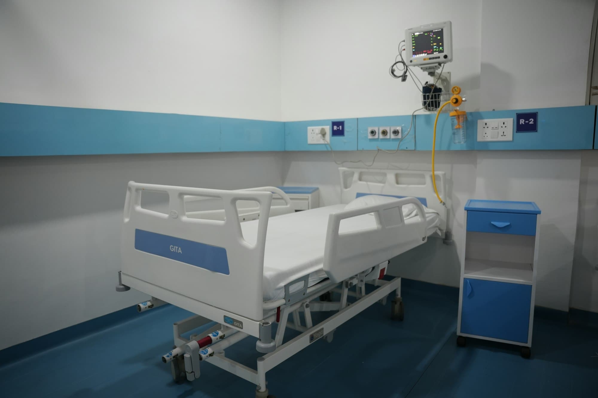 Hospital room with an adjustable bed, patient monitor, and bedside cabinet
